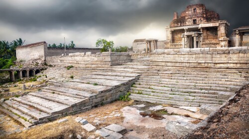 Ancient ruins of Vijayanagara Empire at dramatic overcast sky in Hampi, Karnataka, India